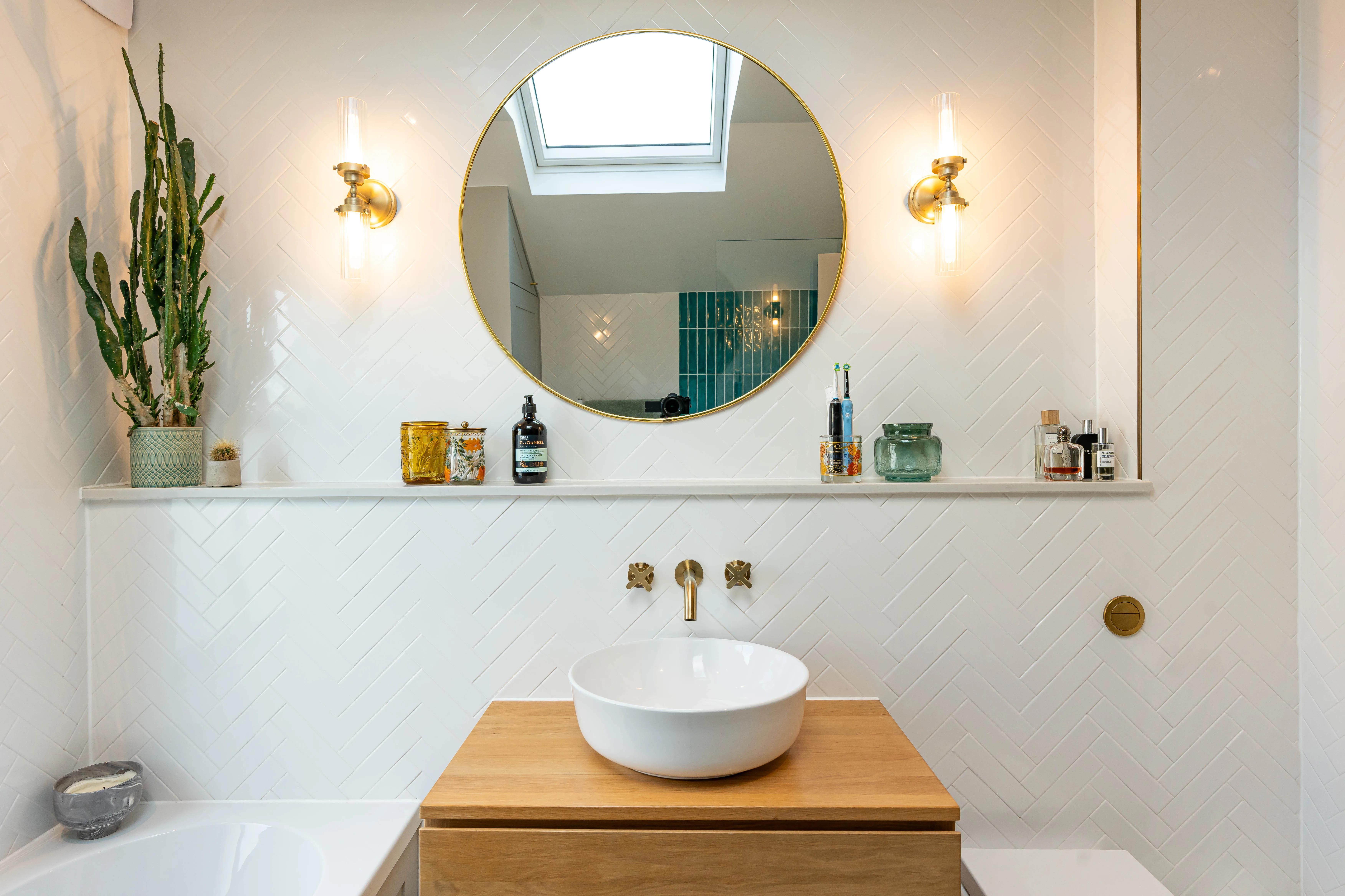 Modern bathroom with round mirror, wooden sink cabinet, and stylish wall decor