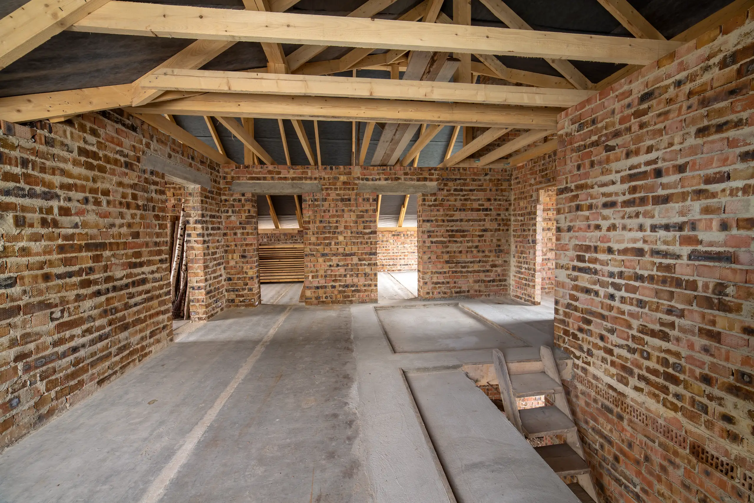 Interior view of a house extension with exposed brickwork and wooden beams