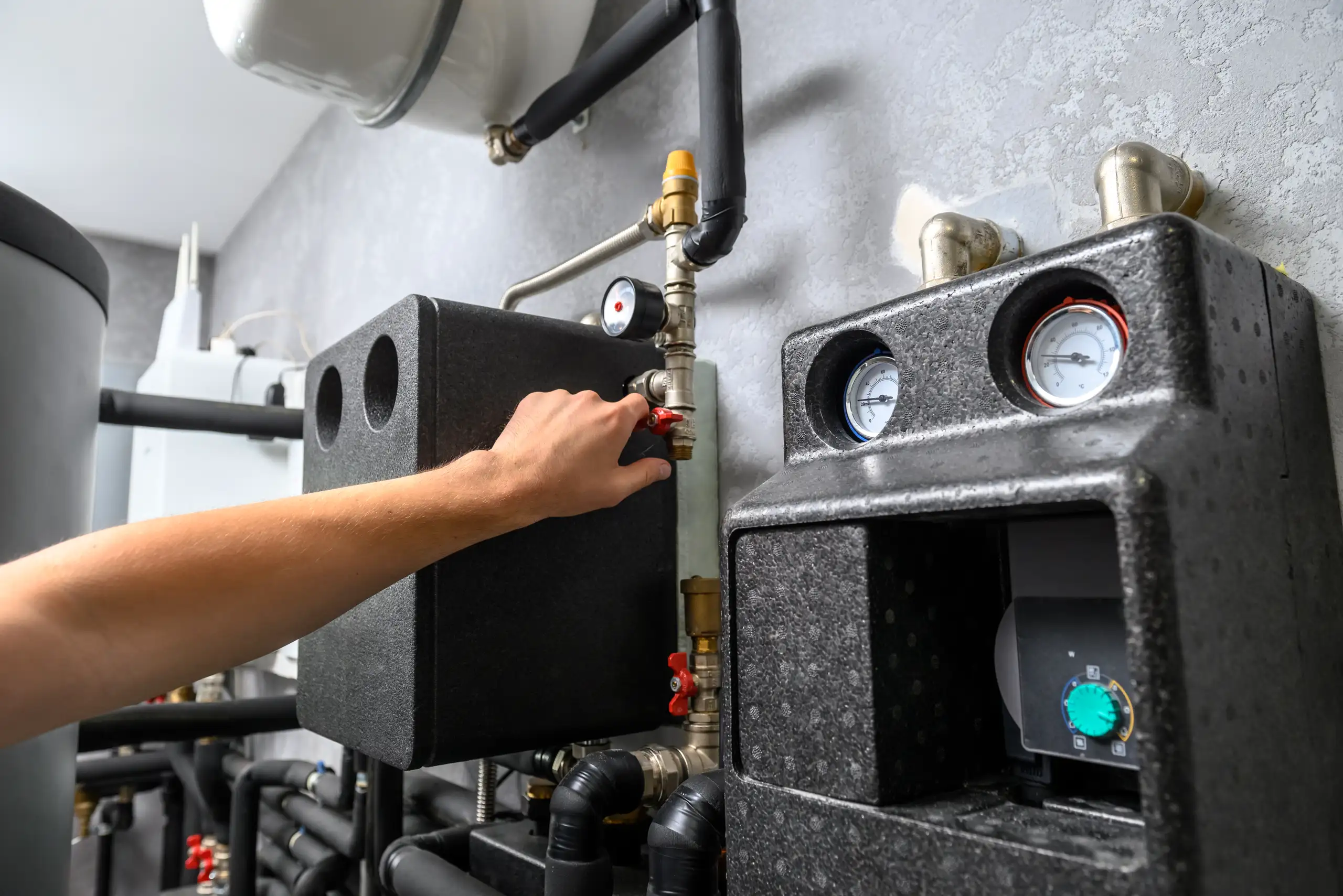 Hand adjusting a valve on a heating system installation