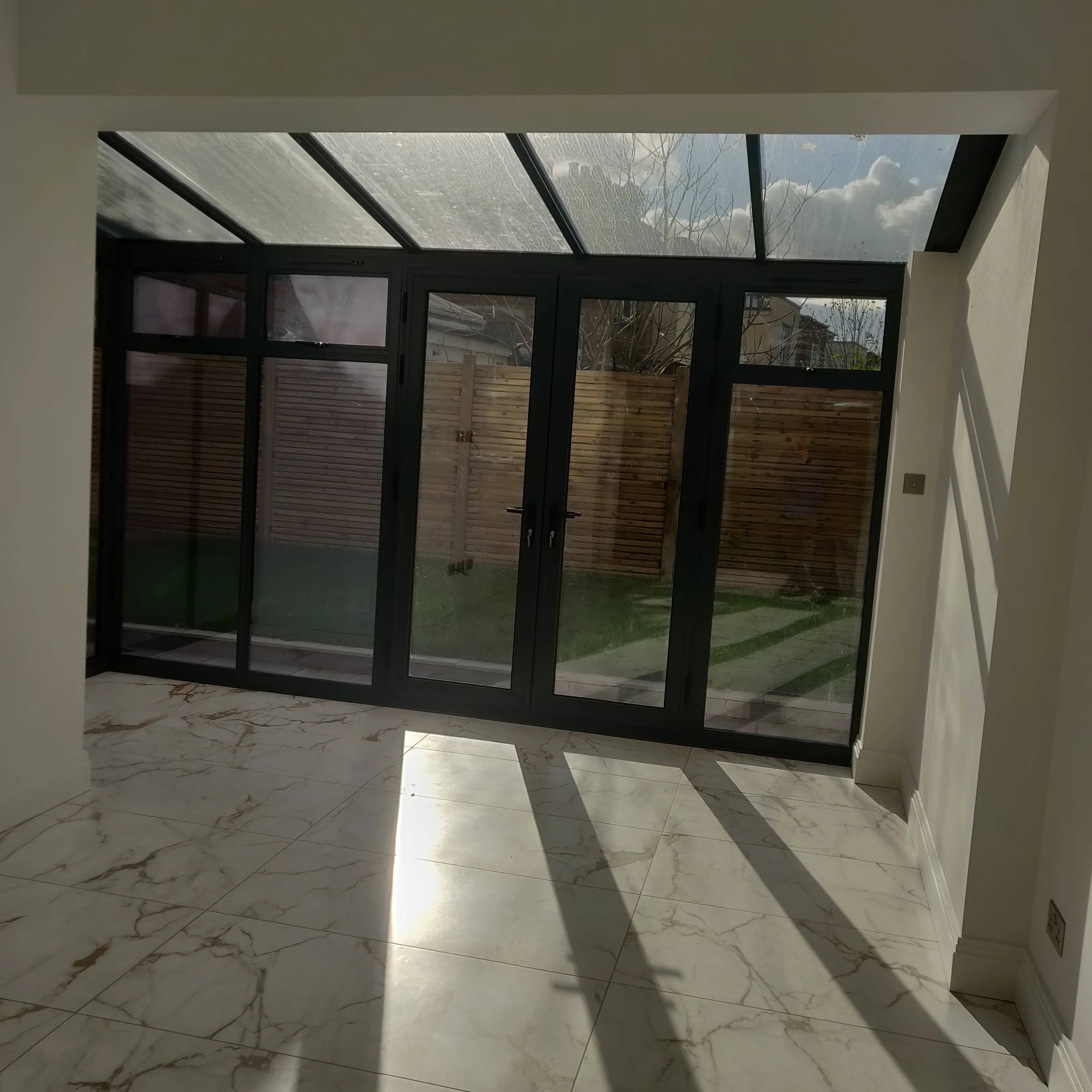 Bright interior of a modern space with large glass doors and marble flooring