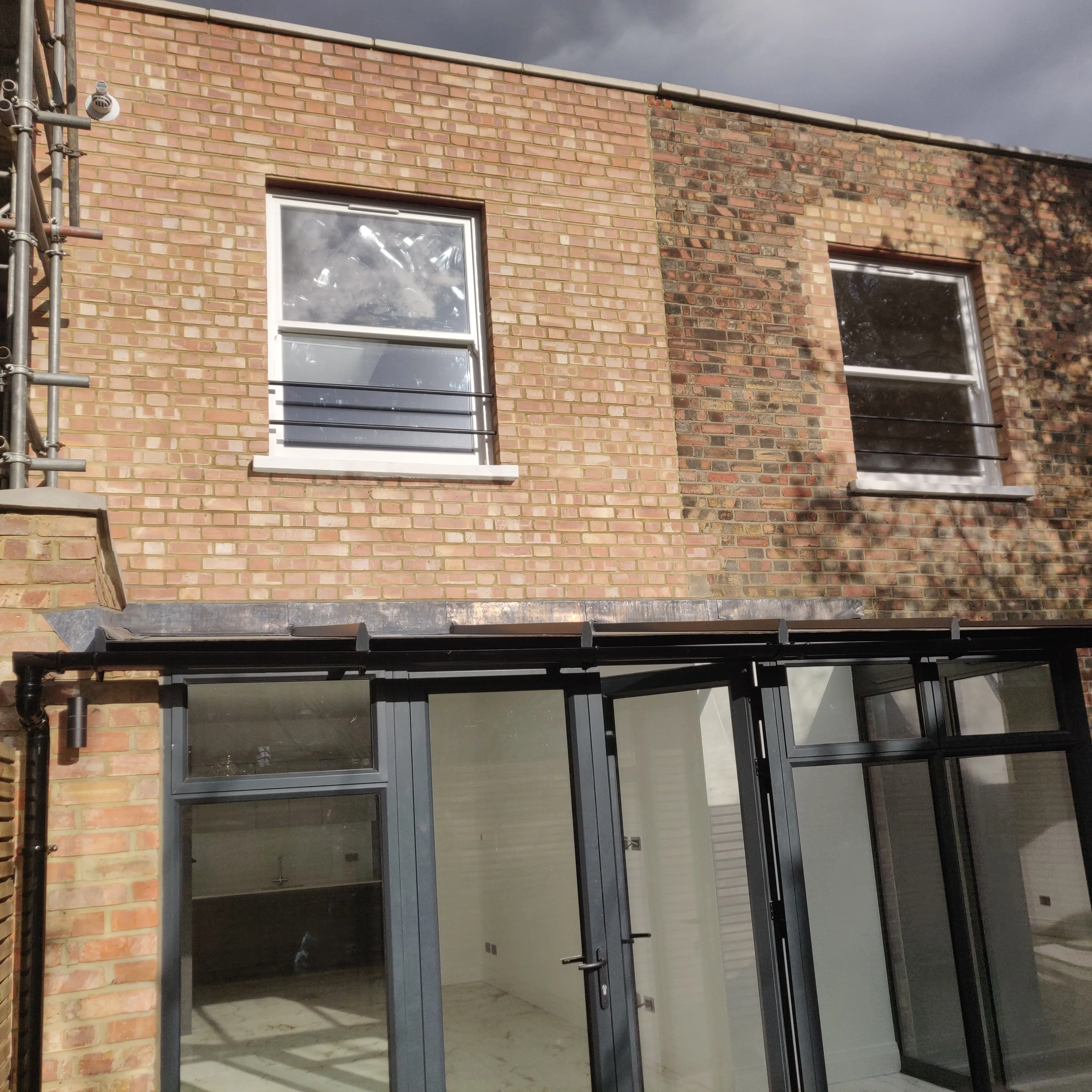 Rear view of a home extension with new windows and a glass conservatory