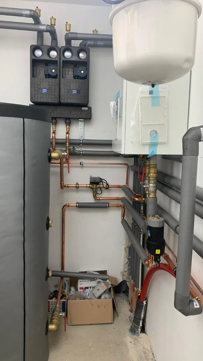 Plumbing installation with copper pipes and a water heater in a modern utility room