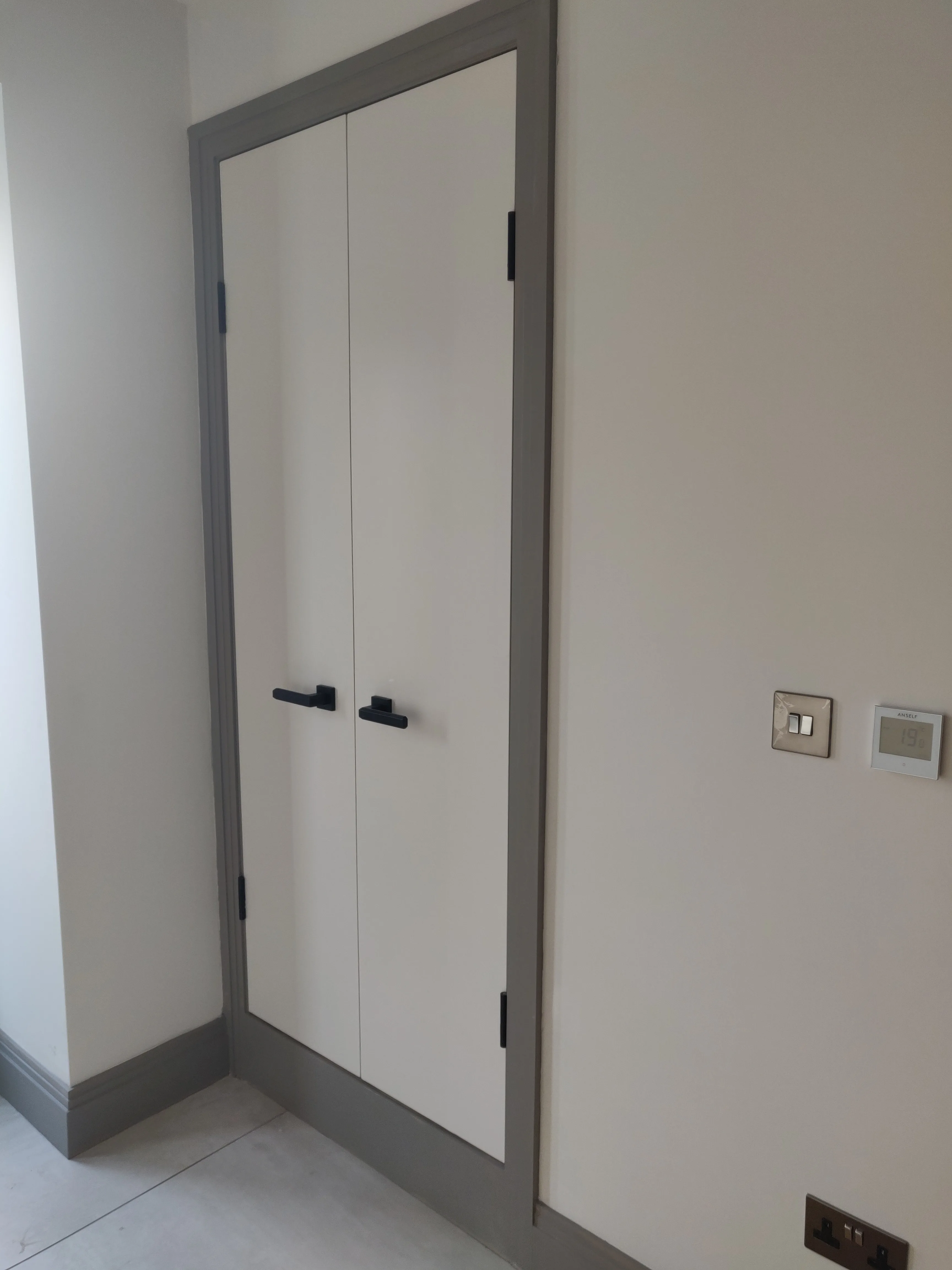 Modern interior featuring a clean, minimalistic cupboard and electrical installation switches
