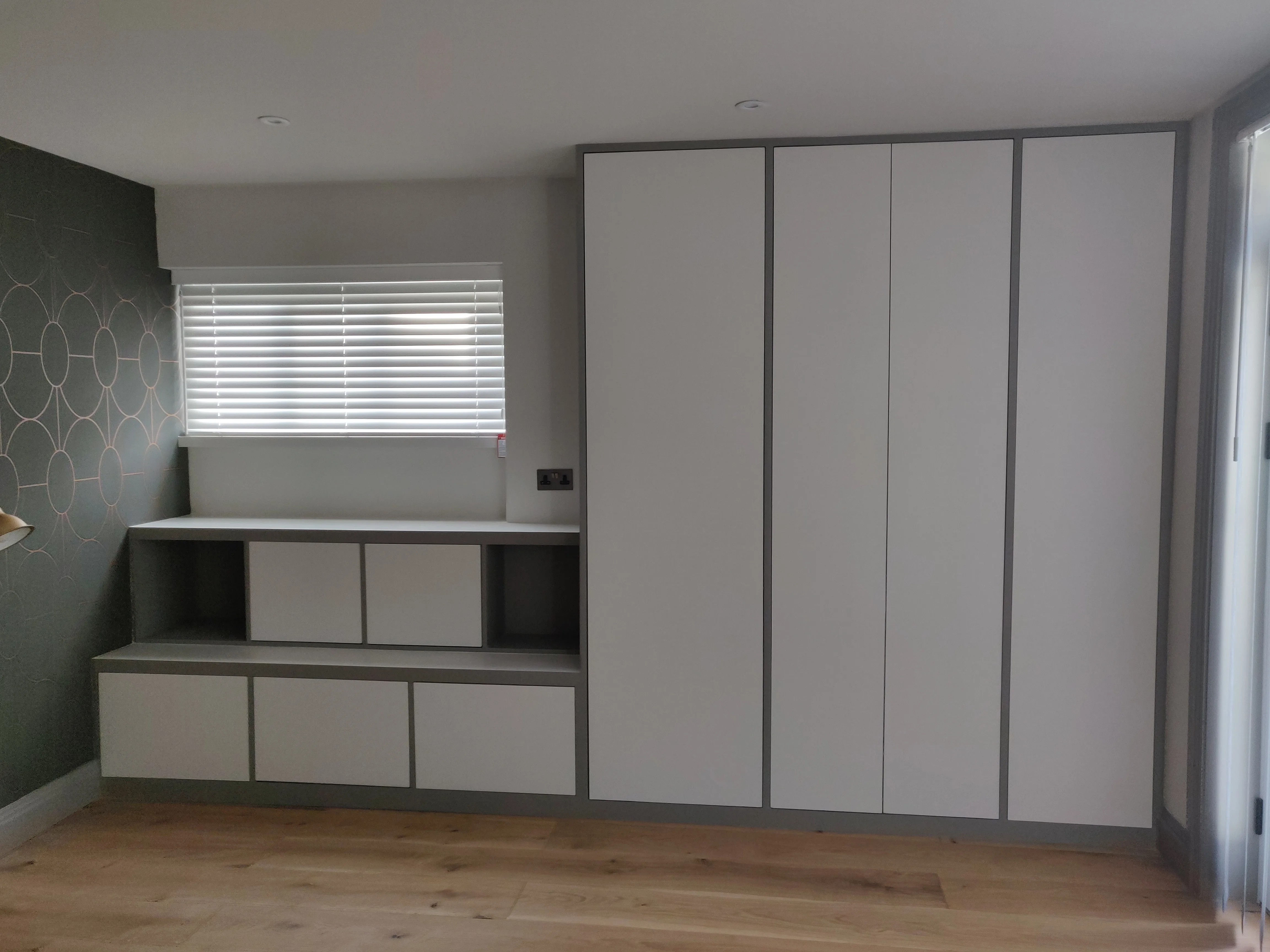 Modern room featuring sleek built-in storage and wooden flooring