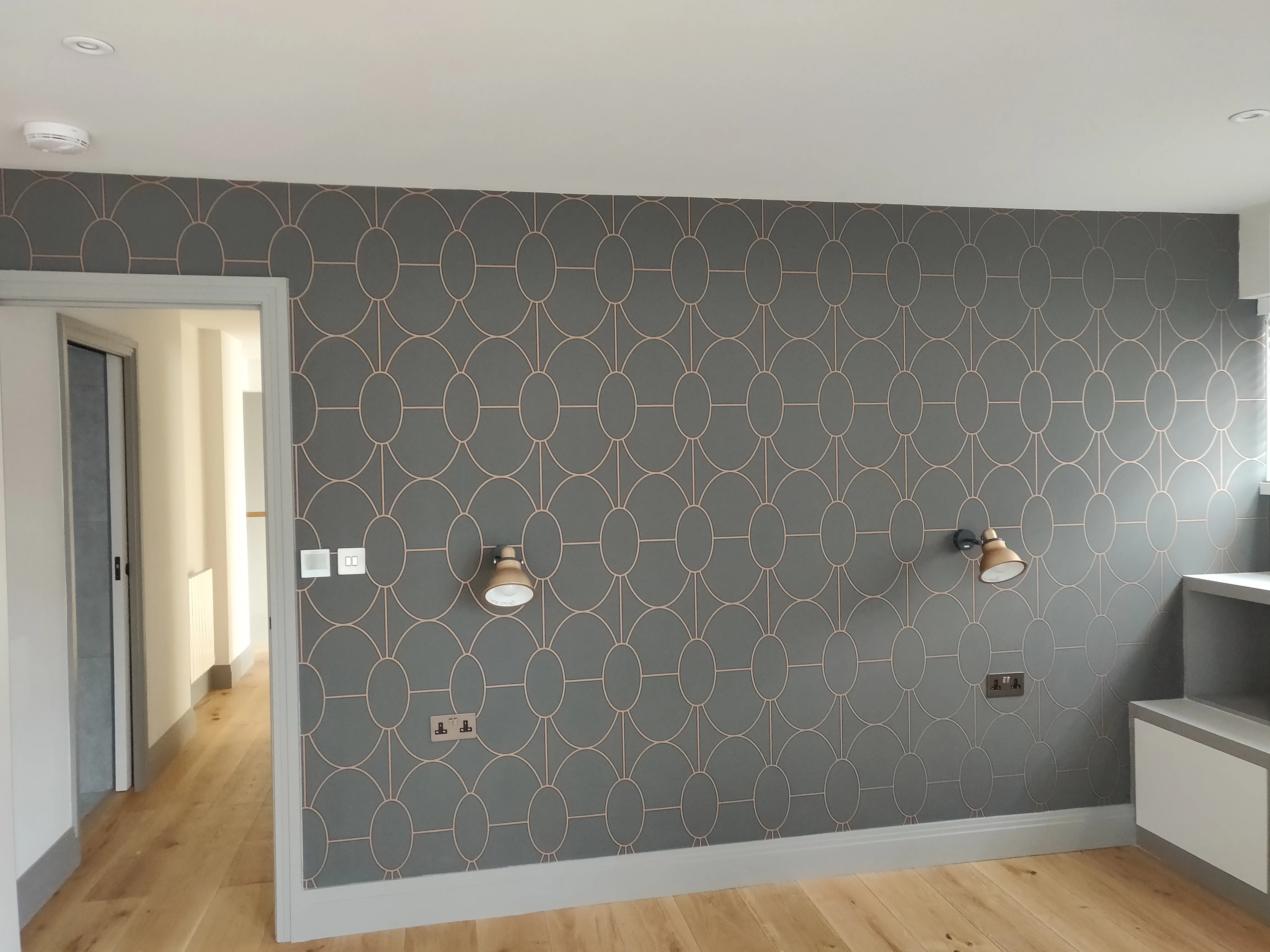 Modern interior featuring patterned wall design and wooden flooring