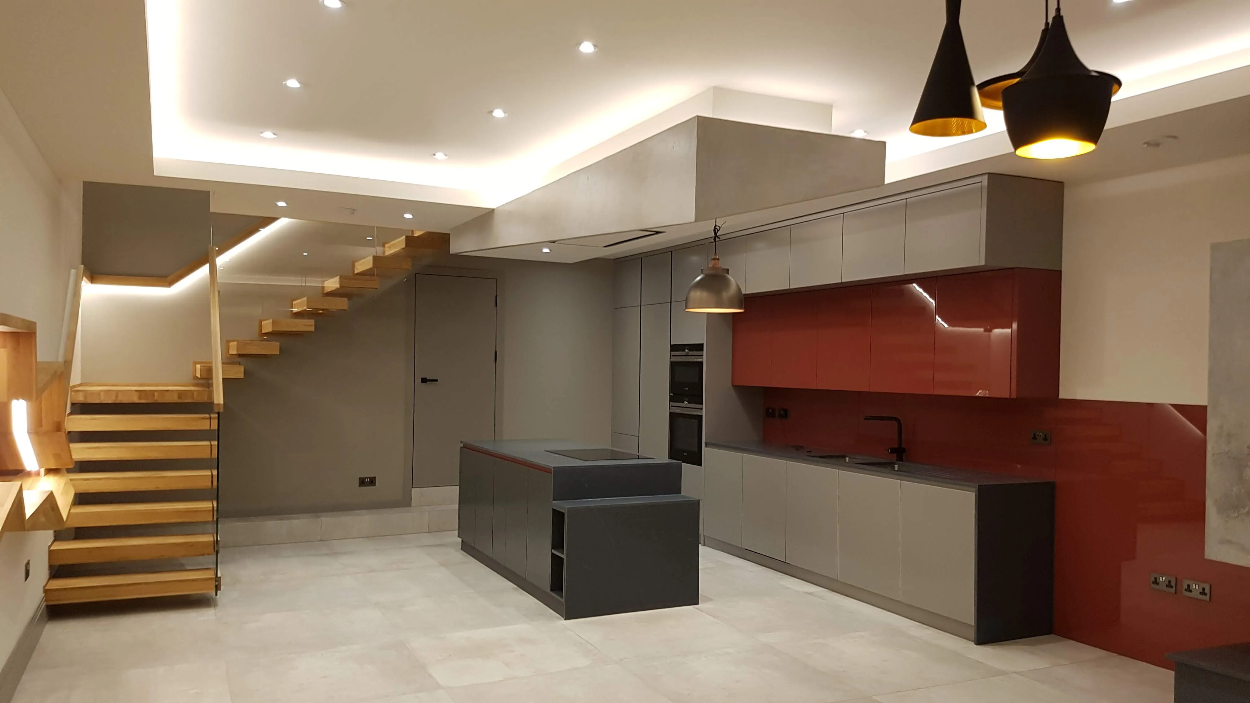 Modern kitchen refurbishment with sleek cabinetry and wooden stairs