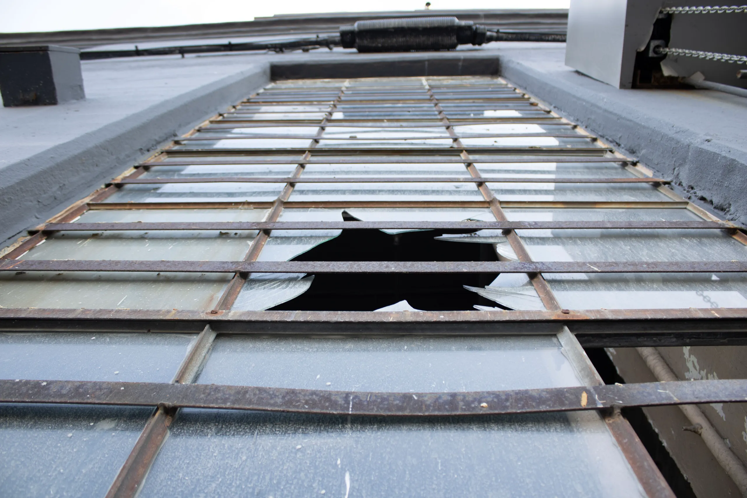 Broken window with a missing pane, showcasing a need for glass repair services