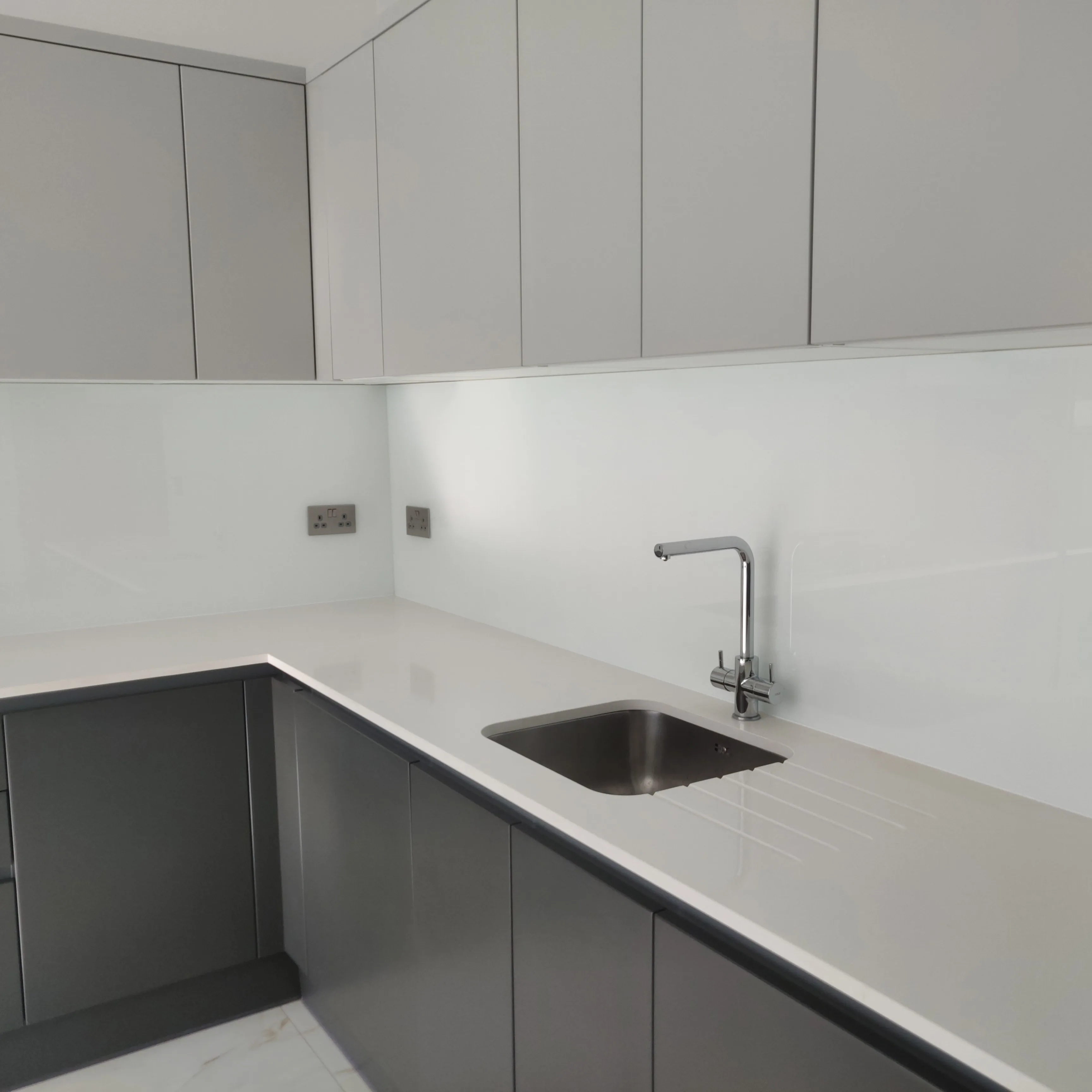 Modern kitchen with sleek grey cabinets and a stainless steel sink